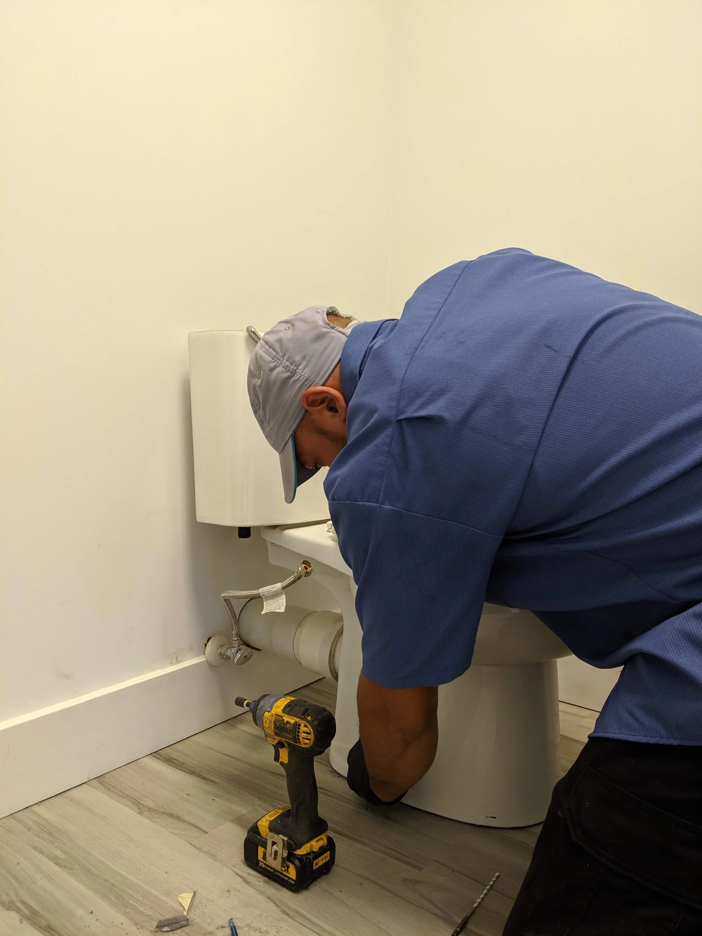 Lapin Services technician checking an indoor plumbing odor source in a bathroom utility access